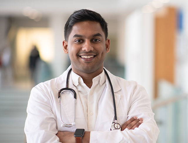 Male doctor with his arms crossed smiling