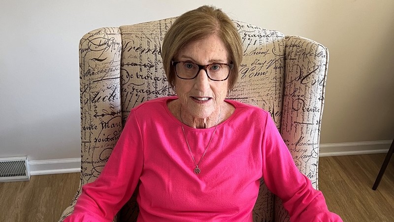 Nancy sitting in a chair in her home