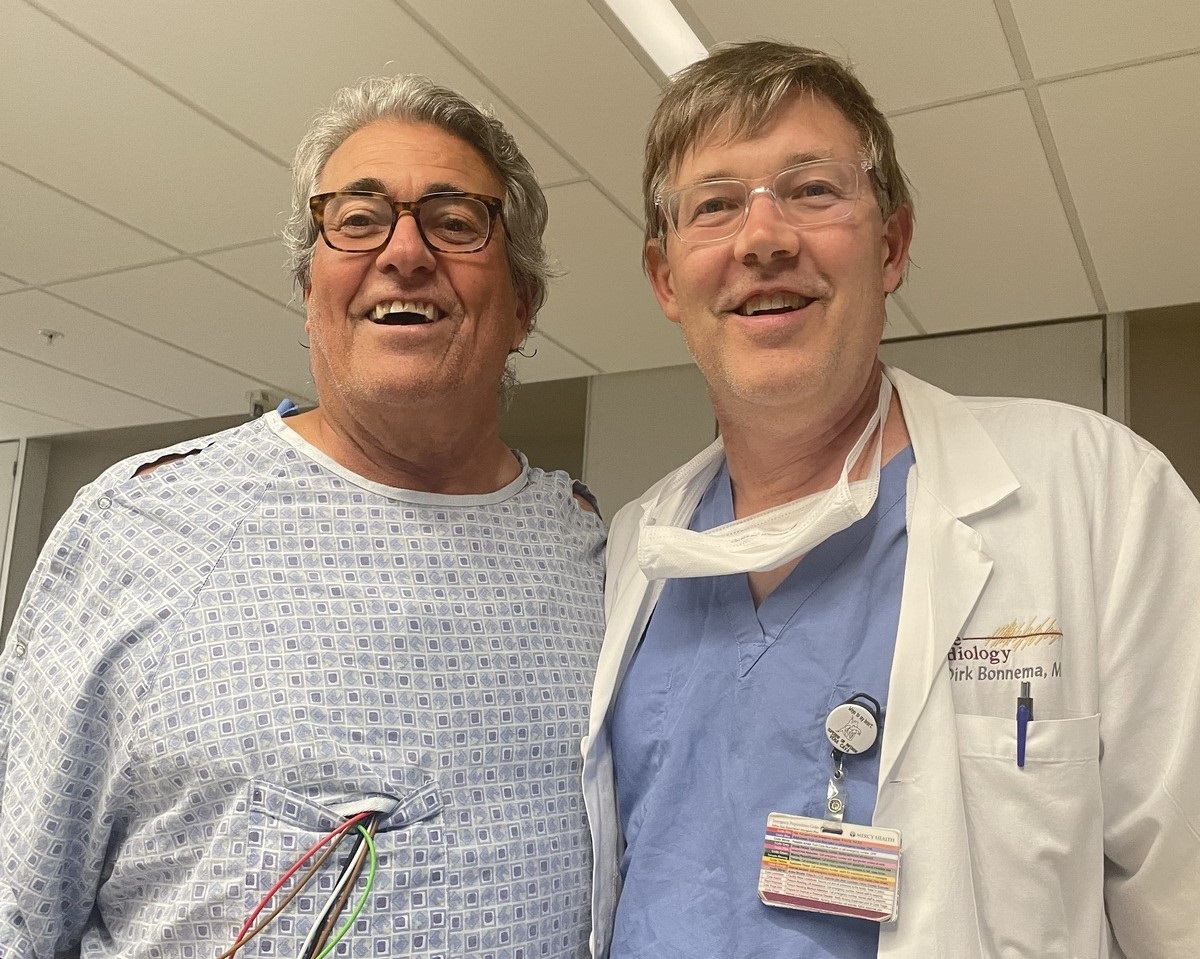 patient standing next to cardiologist in hospital following open heart surgery
